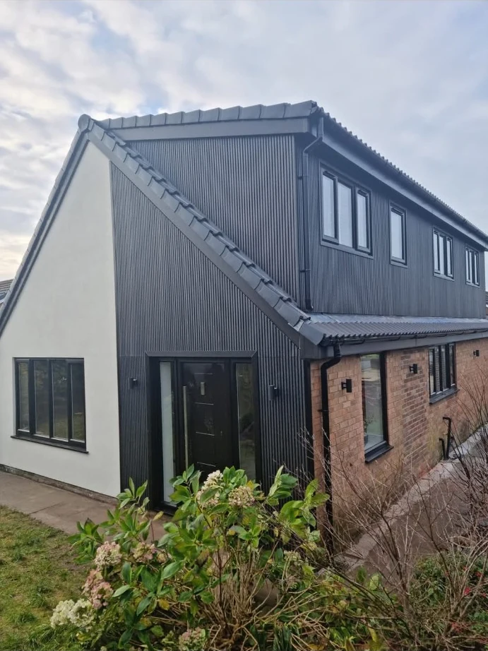 House exterior with dark vertical cladding and brickwork