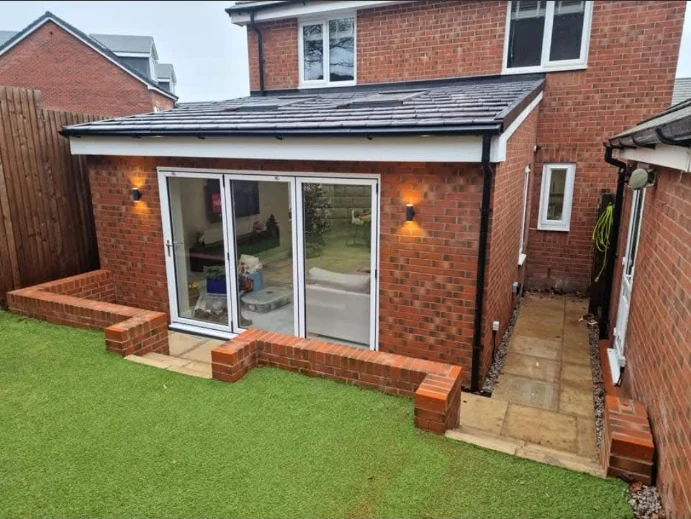 Brick rear extension with patio doors and a tiled roof